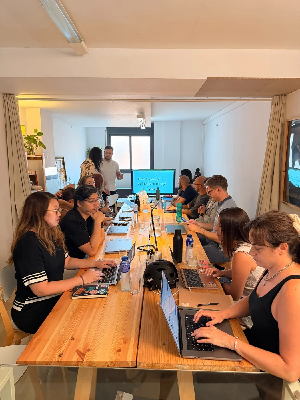 The long table full of laptops during the coworking day at Maui Coworking
